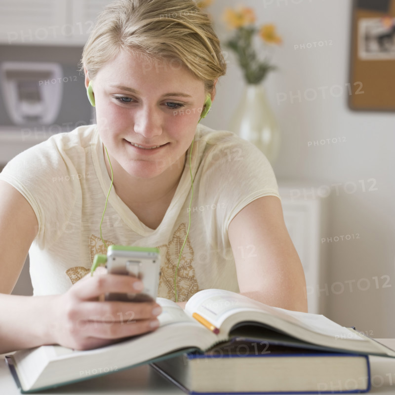 Teenaged girl looking at mp3 player.