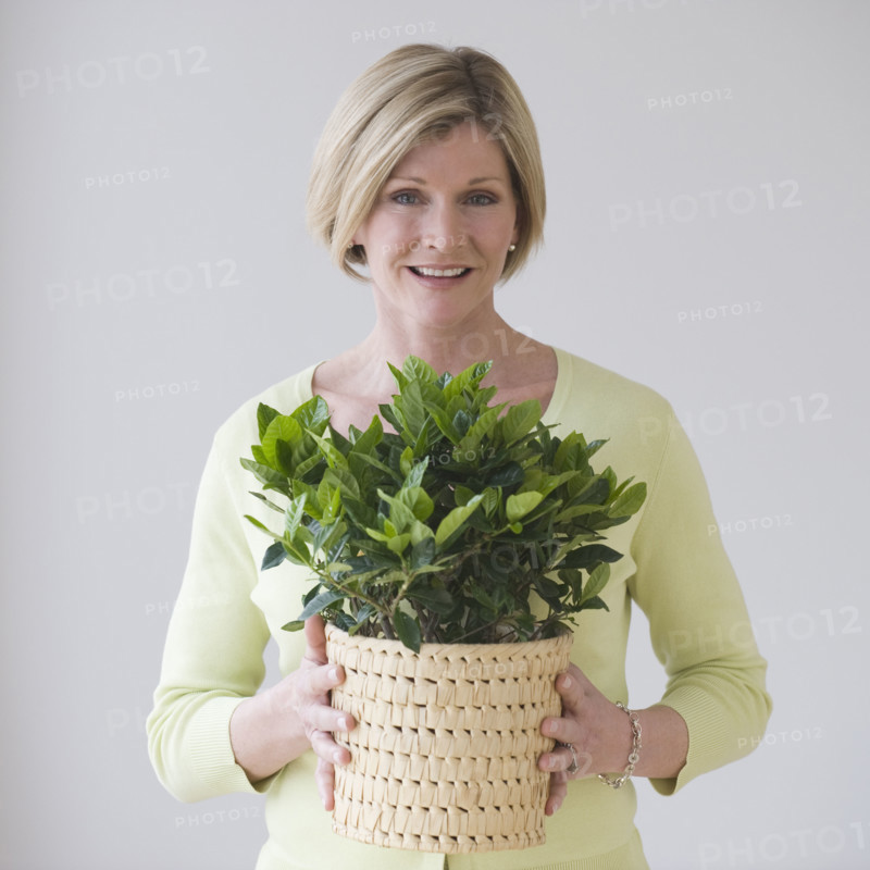 Woman holding potted plant.