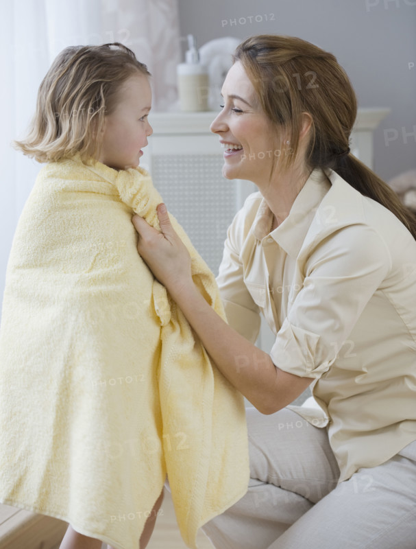 Mother drying daughter with towel.