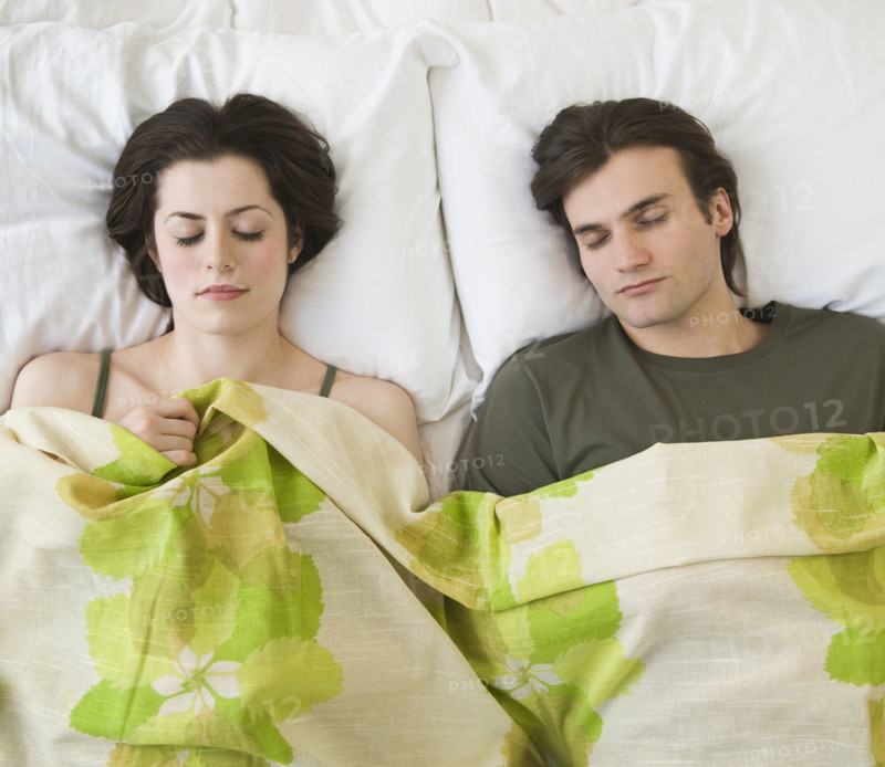 Couple sleeping in bed.