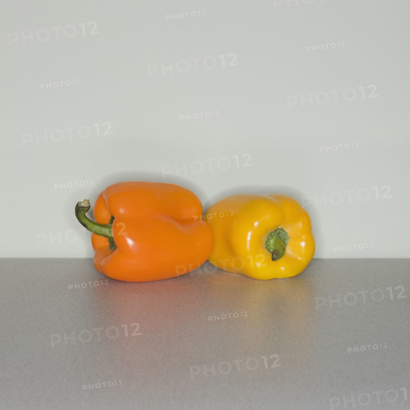 Orange and yellow bell peppers on table.
