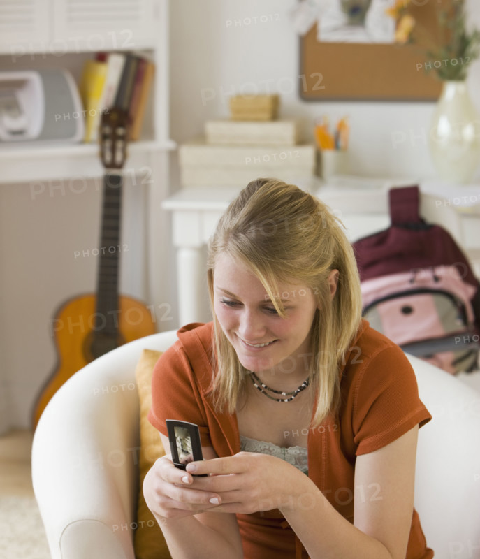 Teenaged girl looking at cell phone.