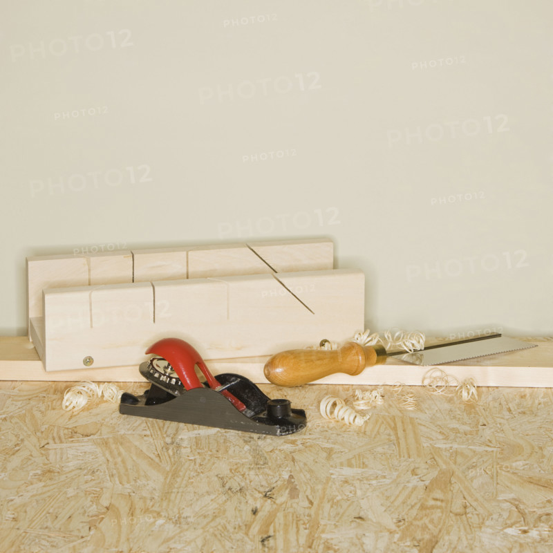 Woodworking plane and awl next to wood blocks.