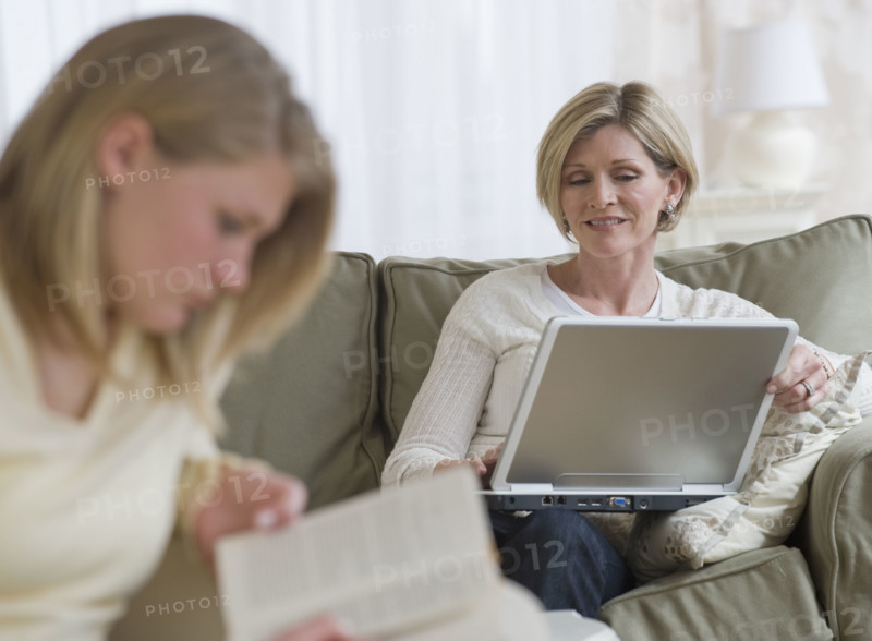Mother and daughter relaxing in livingroom.