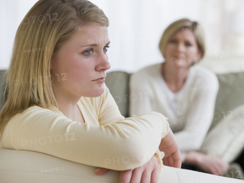 Teenaged girl looking away from mother.