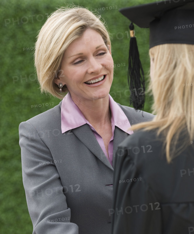 Woman talking to graduate.