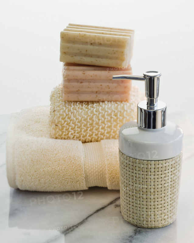 Stack of soap and towels next to lotion.