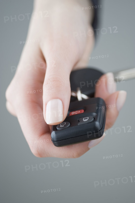 Woman pressing unlock button on keychain.