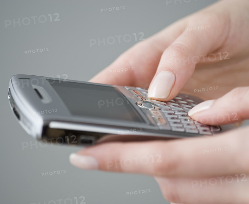 Woman dialing cell phone.