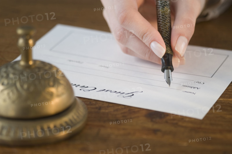 Woman filling out hotel registration.
