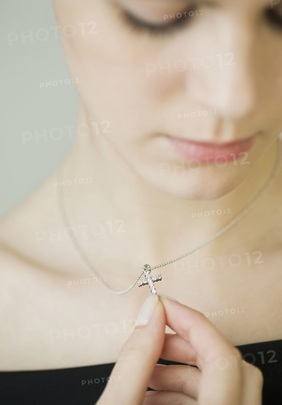 Woman wearing cross necklace.