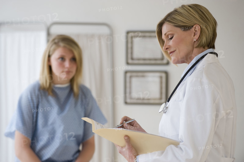 Female doctor reading chart.