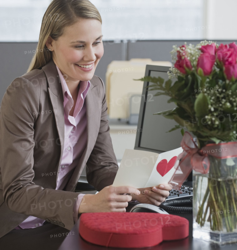 Businesswoman reading Valentine’s Day card.