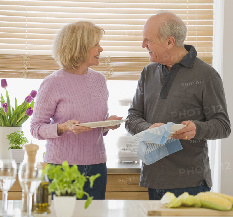 Senior couple drying dishes.