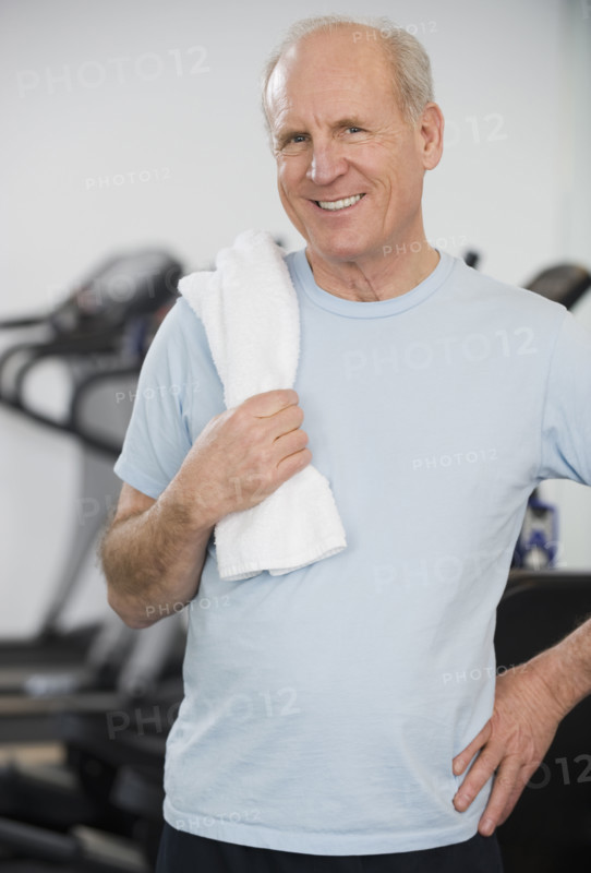 Senior man in front of exercise machines.