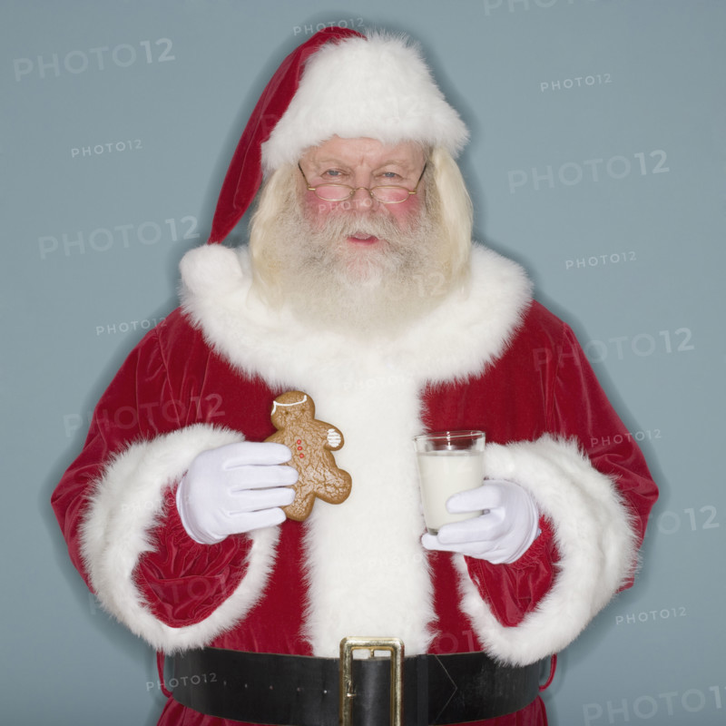Santa Claus holding cookie and milk.