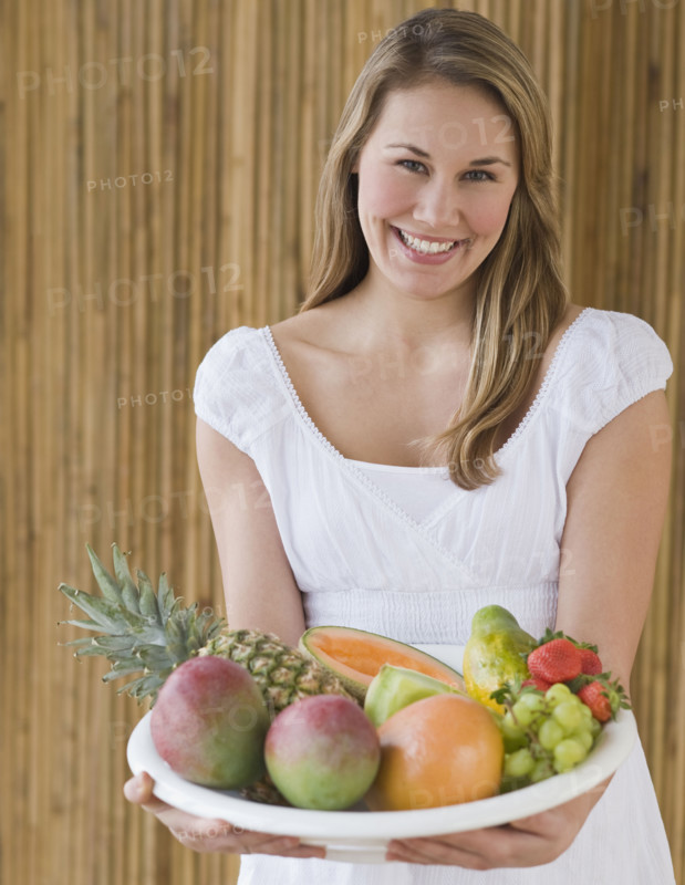 Woman holding bowl of fruit.