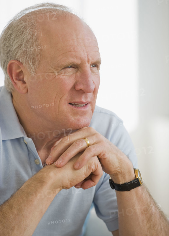 Senior man resting chin on hands.