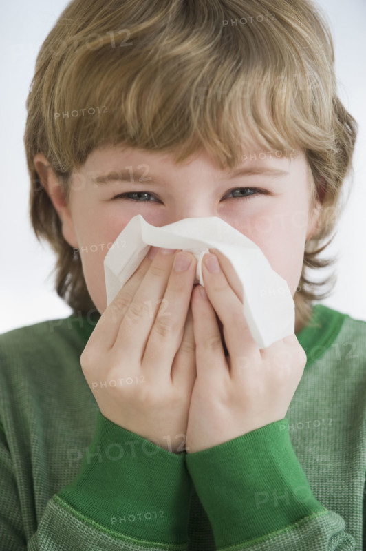 Boy blowing nose.
