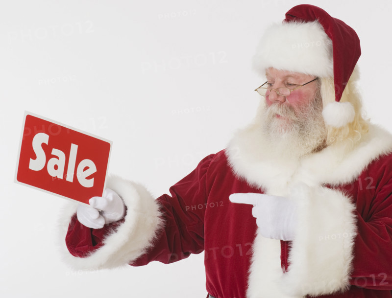 Santa Claus holding Sale sign.