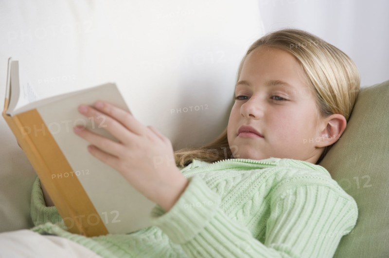 Girl reading on sofa.