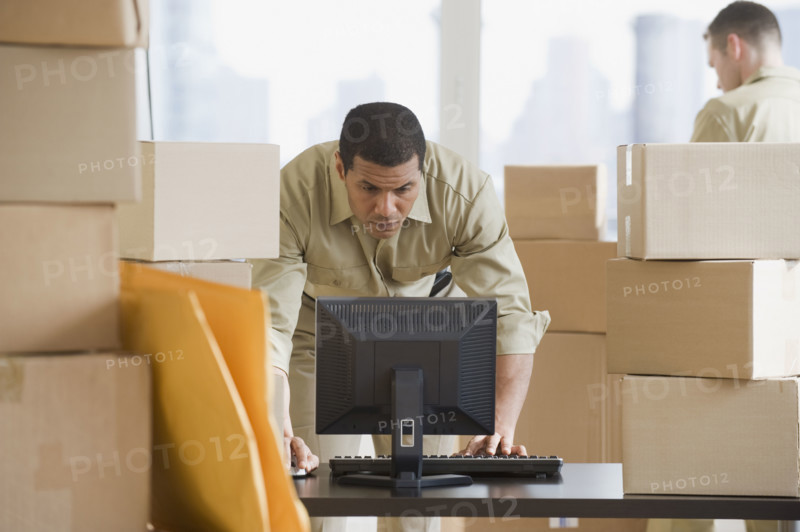 African delivery man looking at computer.
