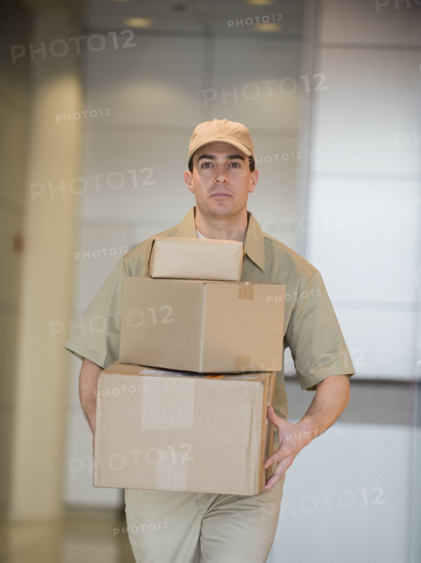 Delivery man carrying stack of packages.