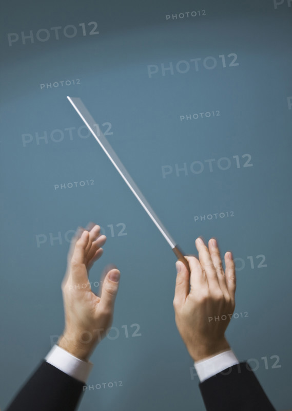 Male conductor’s hands with baton.