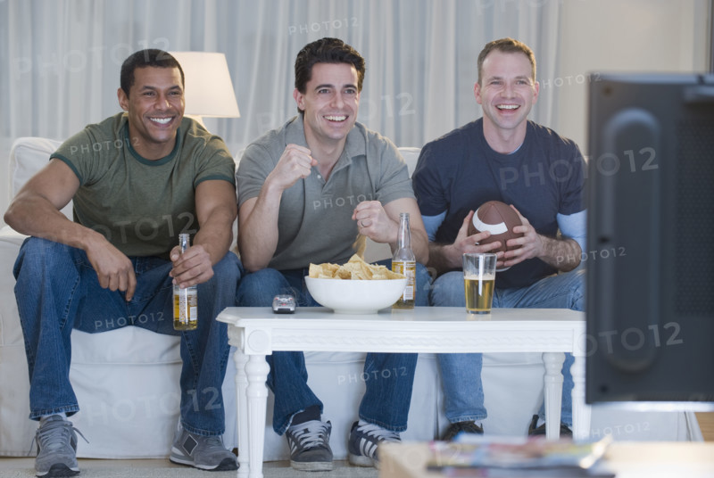 Multi-ethnic men watching sports on television.