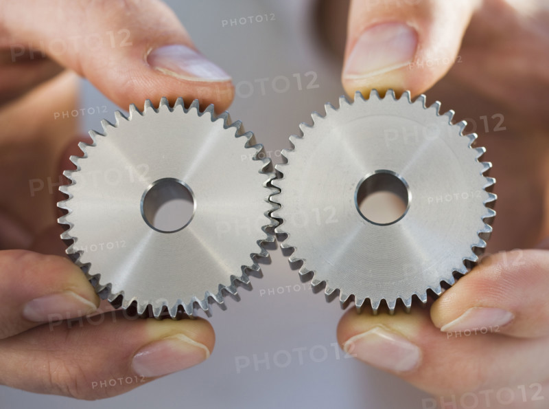 Man holding cog wheels.