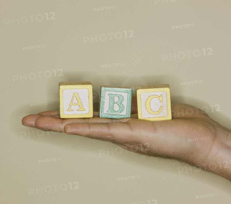 Man holding ABC blocks.