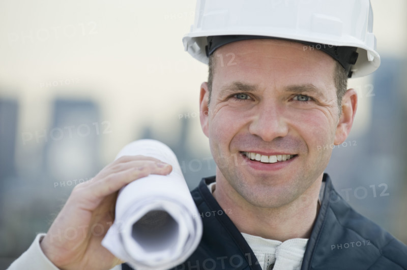 Male construction worker holding blueprints.