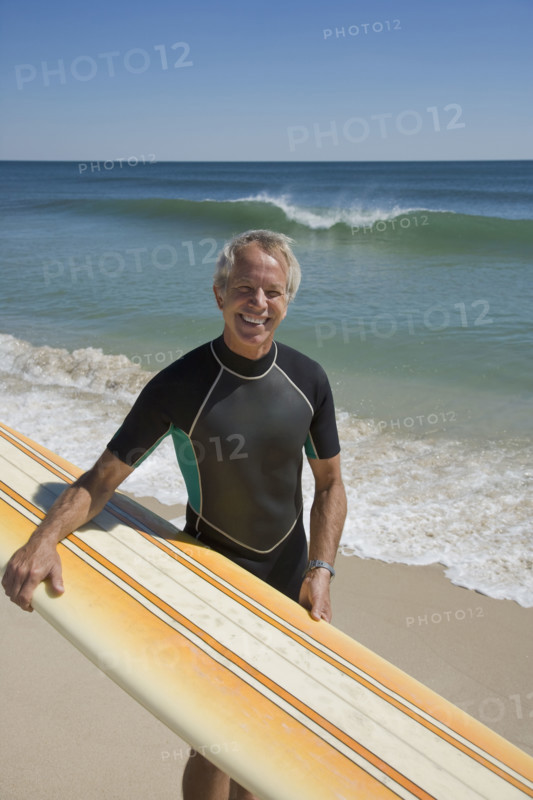 Man holding surfboard at beach.