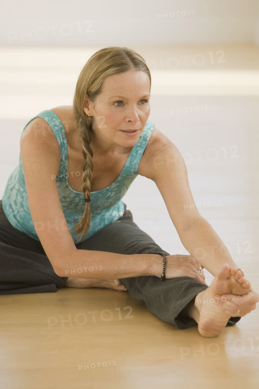 Woman stretching on floor.