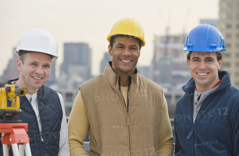 Multi-ethnic male construction workers wearing hard hats.
