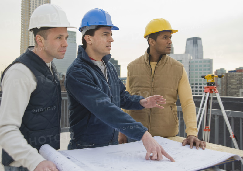 Multi-ethnic construction workers with blueprints.