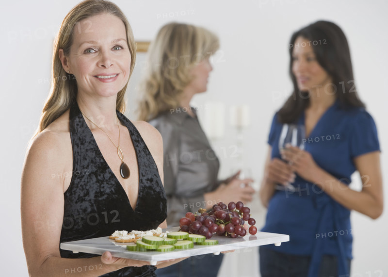 Woman carrying tray of hors d’ouevers.