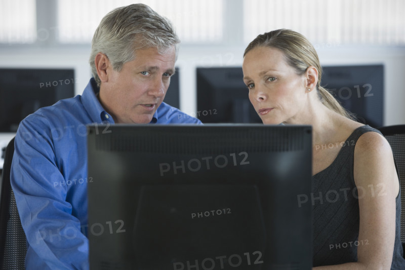 Businesspeople looking at laptop.