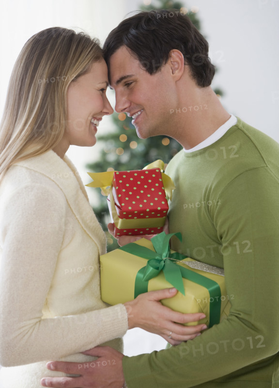 Couple with gifts hugging.