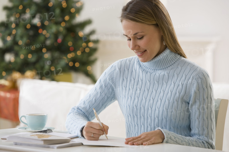 Woman writing at desk.