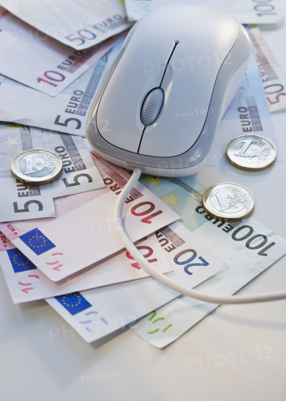 Computer mouse on euro banknotes and coins.