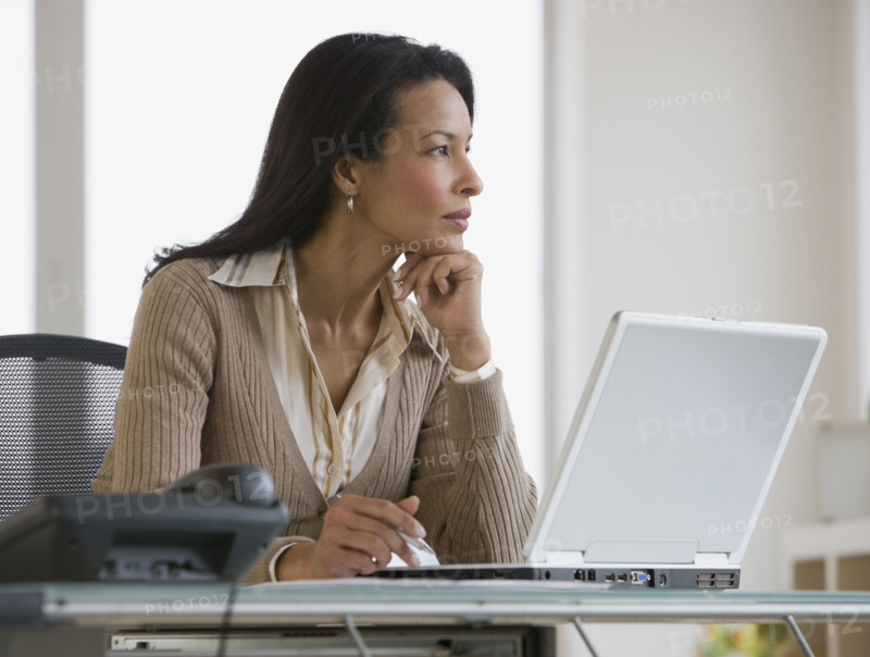 African businesswoman next to laptop.