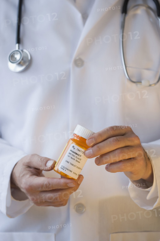 Doctor holding prescription bottle.