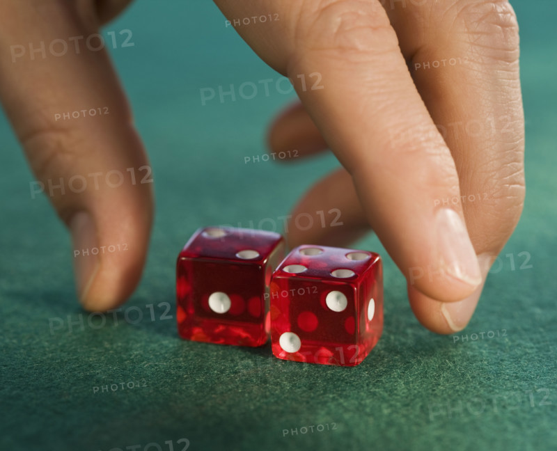 Close up of man reaching for dice.
