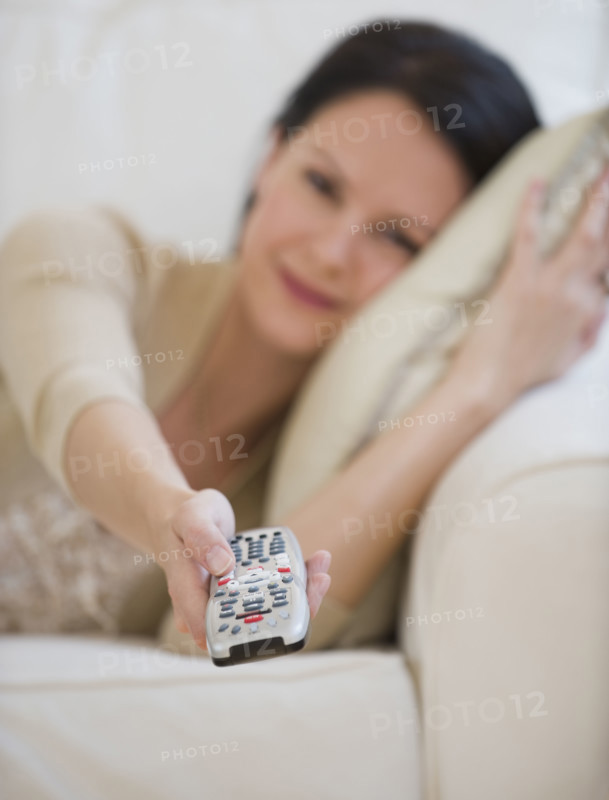 Woman pointing remote control.