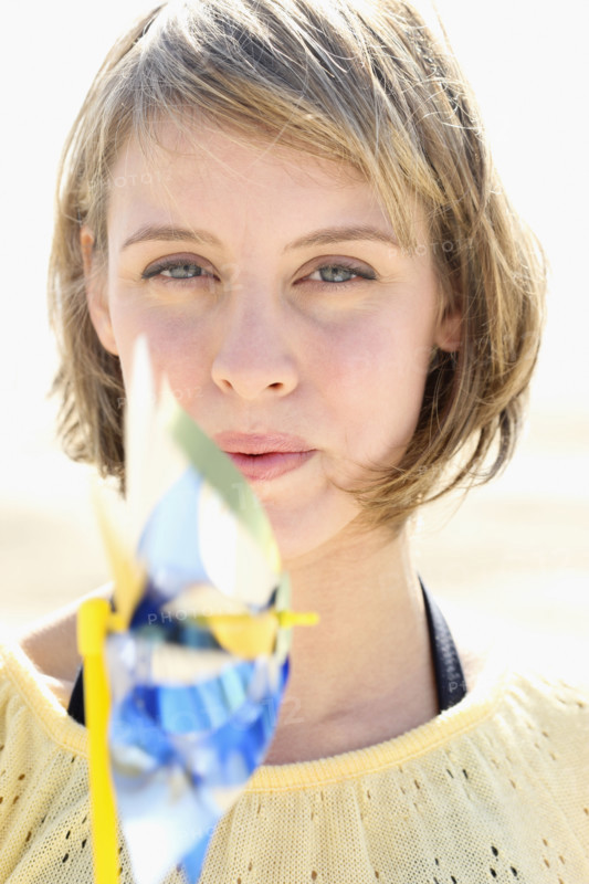 Woman blowing on pinwheel. Date : 2008