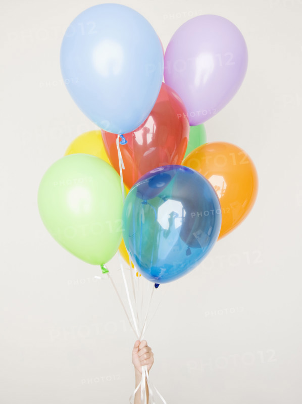 Child holding assorted balloons. Date : 2008