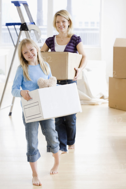 Mother and daughter carrying moving boxes. Date : 2008
