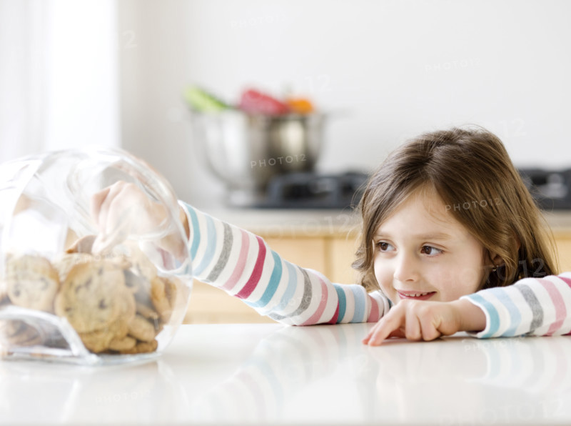 Girl reaching into cookie jar. Date : 2008