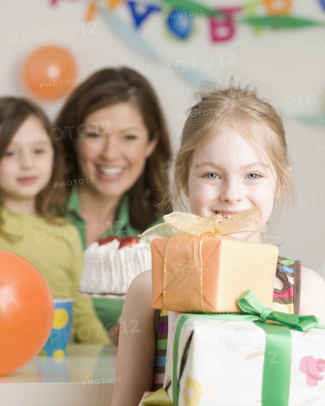 Girl holding stack of birthday gifts. Date : 2008